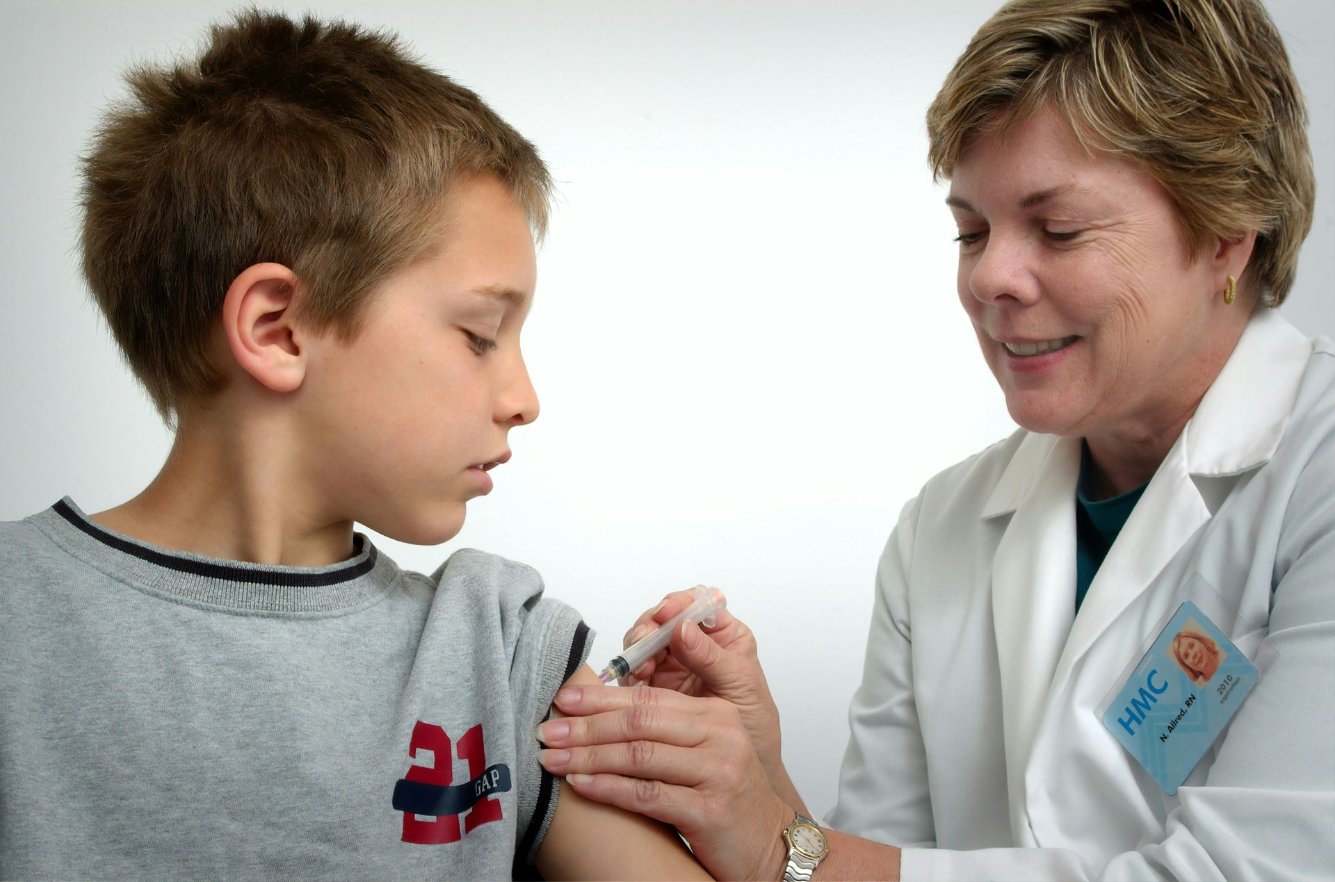 nurse giving vaccination to child